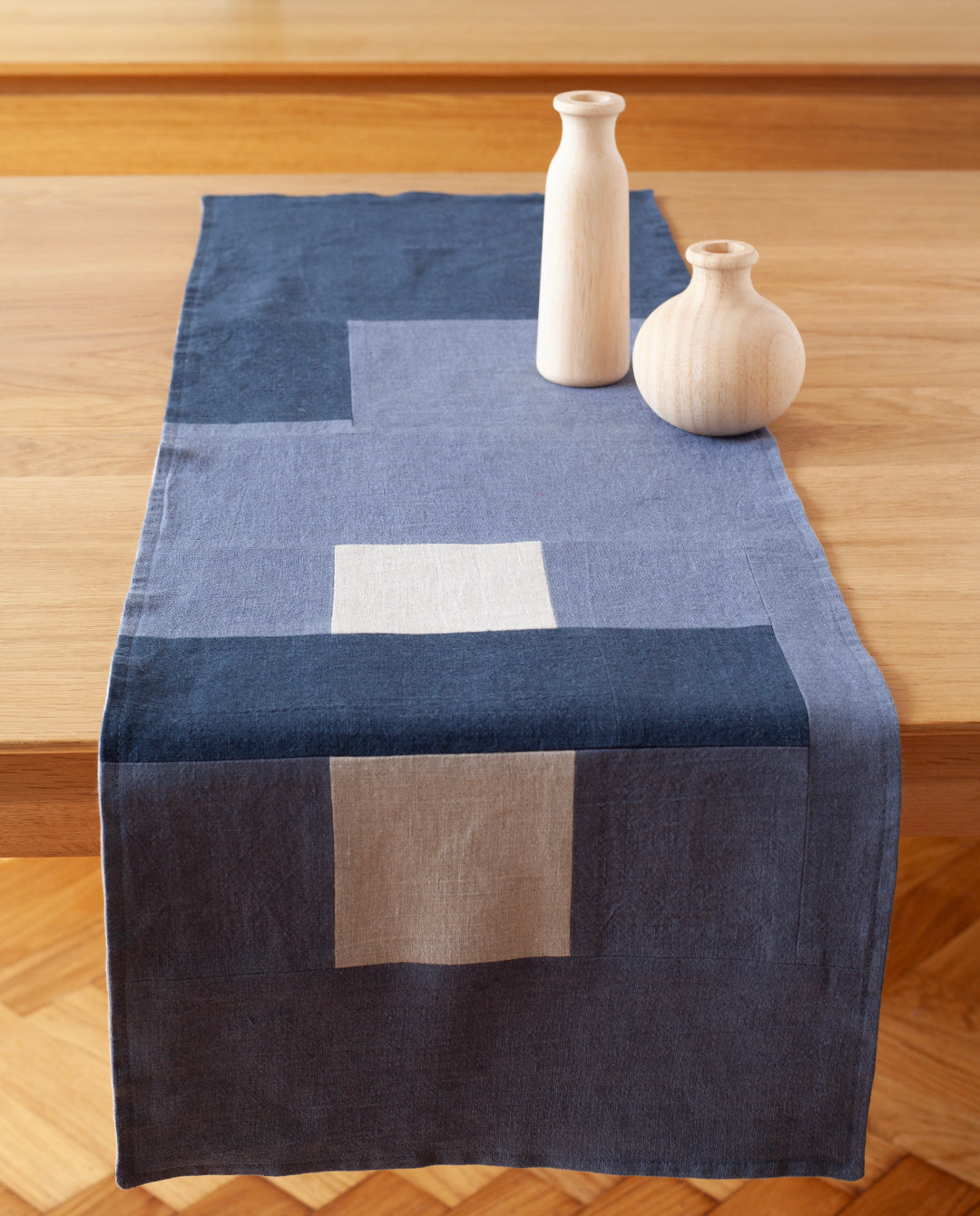 Een overzicht van een blauwe tafelrunner over een tafel. De tafelrunner is ontworpen door Kathryn Clark