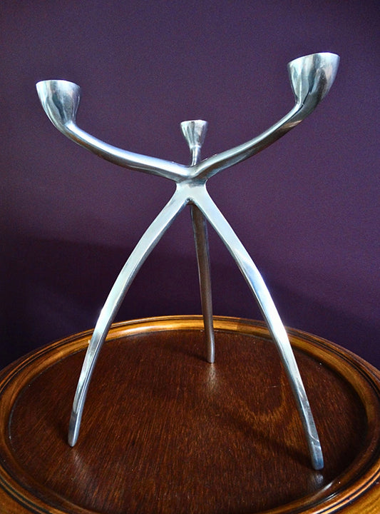 Space Age Aluminium Kandelaar voor drie kaarsen. Gefotografeerd op een tafeltje. Vintage van Atelier Aeris verkrijgbaar bij Draumr