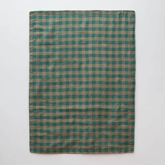 Een productfoto van een deken in groen en beige ontworpen door Kathryn Clark