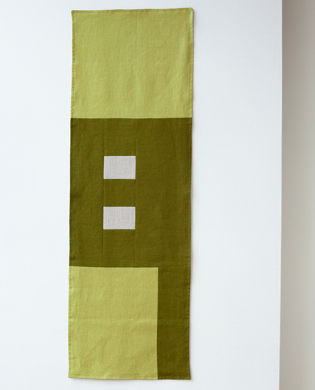 Een productfoto van de mos groene tafelrunner van Kathryn Clark