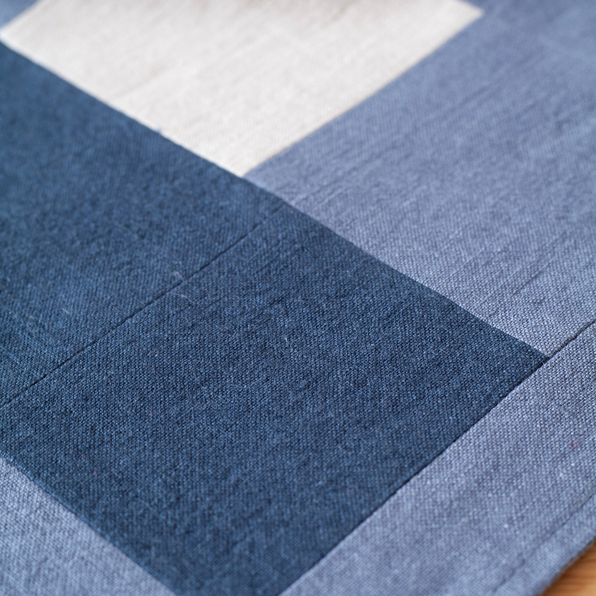 Detailfoto van de blauwe witte tafelrunner. De tafelrunner is ontworpen door Kathryn Clark