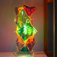 Een tafellamp in de kenmerkende irisiderende sfeer die je kent van Lux Vortex. De lamp is een tafelmodel en staat in een kast De lamp is nu verlicht en je ziet de draad in de lamp zitten.